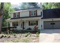 Charming two-story home featuring red shutters, a well-manicured lawn, and an attached two-car garage at 4314 Saddlecreek Ct, Auburn, GA 30011