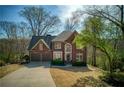 Beautiful brick home with manicured lawn, two-car garage, and mature trees at 2275 Barrett Dr, Cumming, GA 30040
