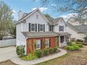 Traditional two-story home featuring a brick facade, attached garage, and neatly landscaped front yard at 4845 Weathervane Dr, Alpharetta, GA 30022