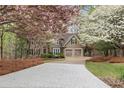 Beautiful home with flowering trees in the front yard and a long, patterned driveway at 525 Sycamore Pt, Woodstock, GA 30189