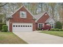 Charming brick home with attached garage, landscaped front yard, and well-maintained lawn at 1145 Prospect Mill Dr, Lawrenceville, GA 30043