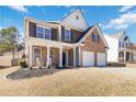 Charming two-story home with brick and siding, inviting front porch with chairs, and a two-car garage at 416 Pine Log Ct, Canton, GA 30115
