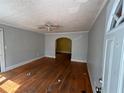View of the living room with hardwood floors, a ceiling fan, and an arched doorway at 675 Sowell Rd, Mcdonough, GA 30252