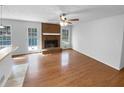 Open-concept living room with hardwood floors and a brick fireplace at 160 Benjamin Cir, Fayetteville, GA 30214