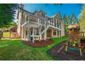 Multi-level deck with staircase overlooks the lush green yard with mature trees and play area at 6186 Talmadge Nw Run, Acworth, GA 30101