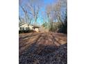 Expansive backyard with mature trees and a flat grassy area, ideal for outdoor activities at 4985 Doby Ln, Austell, GA 30106