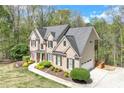 An elevated view of a brick home with siding, mature trees, and a long driveway at 2830 Willow Hill Ct, Cumming, GA 30040
