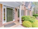 Close-up of the front door, brick exterior, and manicured landscaping create a welcoming entrance at 2830 Willow Hill Ct, Cumming, GA 30040