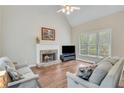 Bright living room features a vaulted ceiling, fireplace, and large windows overlooking the deck at 2830 Willow Hill Ct, Cumming, GA 30040