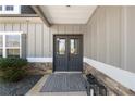 Inviting front entrance with stylish double doors, stone accents and modern lanterns at 7500 Gillespie Pl, Douglasville, GA 30135