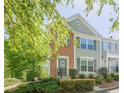Two-story townhouse with brick accents, gray siding, and lush green trees at 9155 Nesbit Ferry Rd # 65, Alpharetta, GA 30022