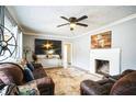 Cozy living room with a ceiling fan, fireplace, and comfortable brown leather sofas at 265 Winding Stream Trl, Hampton, GA 30228