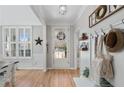 Bright foyer featuring hardwood floors, a white bench, and a decorative coat rack at 997 Woodbury Rd, Canton, GA 30114