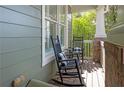 Inviting front porch featuring two rocking chairs with cushions; perfect for relaxing outdoors at 997 Woodbury Rd, Canton, GA 30114