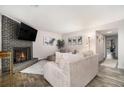 Bright living room features a brick fireplace, TV, wood-look flooring and neutral decor at 2112 Palmyra Dr, Marietta, GA 30067