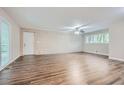 Spacious living room with hardwood floors, a ceiling fan, and a brick wall at 2184 Pemberton Sw Rd, Atlanta, GA 30331