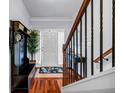 Entryway with wood floors, staircase with black iron railings, and coat rack at 1829 Appaloosa Mill Ct, Buford, GA 30519