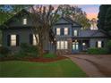 Charming two-story home featuring stone accents, a well-manicured lawn, and a vibrant blue front door at dusk at 135 High Point Walk, Atlanta, GA 30342