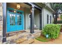 Inviting front porch with stone steps, black columns, and a vibrant blue double door at 135 High Point Walk, Atlanta, GA 30342