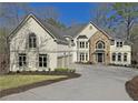 Beautiful home with a three-car garage, stucco exterior, stone accents, large driveway, and well-maintained landscaping at 545 Slane Trce, Roswell, GA 30076