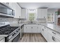 Well-equipped kitchen featuring stainless steel appliances, white cabinets, and granite countertops at 904 Little River Ln, Woodstock, GA 30189