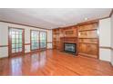 Bright living room featuring hardwood floors, a fireplace, built-in shelving, and access to the deck at 3684 Wittenburg Ct, Decatur, GA 30034