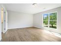 Bright bedroom with wood floors, a large window and a door to the bathroom at 4490 Thornwood Trl, Stone Mountain, GA 30083
