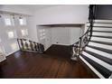 Open living room with dark hardwood floors, staircase, and ample natural light from large windows at 819 Venetta Nw Pl, Atlanta, GA 30318