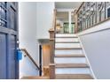 Inviting entryway with hardwood stairs, a wrought iron railing, and views into the kitchen at 921 Creekdale Dr, Clarkston, GA 30021