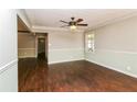 Neutral living room with hardwood floors, ceiling fan, crown molding and large window at 5798 Salem Rd, Covington, GA 30016