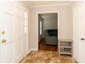 Foyer featuring a white door, tile flooring, coat closet, and a view into the hardwood-floored living room at 1468 Cheyenne Ct, Stone Mountain, GA 30087