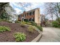 Side view of home with a brick front, light yellow siding, and driveway leading to a detached two-car garage at 1510 Wood Thrush Way, Marietta, GA 30062