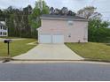 View of the rear of the house with a two-car garage and long driveway at 3763 Waldrop Hills Dr, Decatur, GA 30034