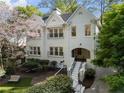 Charming white brick home with blooming tree, bench, and inviting curb appeal at 1503 Emory Ne Rd, Atlanta, GA 30306