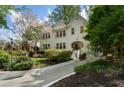 Charming white brick home with blooming tree, bench, and inviting curb appeal at 1503 Emory Ne Rd, Atlanta, GA 30306