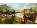 A beautiful home featuring a gated yard with fresh green grass and a quaint mailbox near the road at 1718 Pucketts Sw Dr, Lilburn, GA 30047