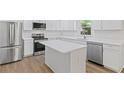 Modern kitchen showcasing white cabinetry, stainless steel appliances, and a functional center island for meal preparation at 3406 Randell Brown Avenue Unit 3, Atlanta, GA 30354