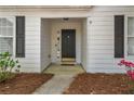 Home front entrance with black door, white siding, black shutters, and small front garden at 5882 Riverside Walk Dr, Sugar Hill, GA 30518