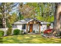 Charming brick home with a welcoming front porch and a lush green lawn and mature trees at 2322 Poplar Springs Ne Dr, Brookhaven, GA 30319