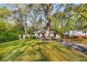 Charming brick home with a welcoming front porch and a lush green lawn with mature trees at 2322 Poplar Springs Ne Dr, Brookhaven, GA 30319