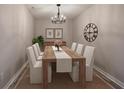 Dining room with seating for eight featuring modern chandelier and décor at 380 Inman Rd, Fayetteville, GA 30215