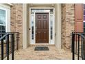 A classic brown front door with sidelights welcomes visitors into this traditional brick home at 426 Vera Park Pl, Alpharetta, GA 30022