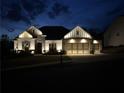 Exterior shot of a home at night showcasing landscape and architectural lighting on the house and driveway at 432 Horizon Trl, Canton, GA 30114