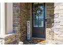 Inviting front door framed by stone, adorned with a wreath, and a cheerful welcome sign at 432 Horizon Trl, Canton, GA 30114