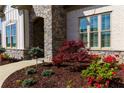 Up-close view of landscaping featuring stacked stone, mulch, and various red flowering plants near the front entrance at 432 Horizon Trl, Canton, GA 30114