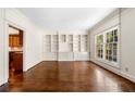 Open living room showcasing hardwood floors, built-in shelving, natural lighting, and view to the kitchen at 51 Ivy Chase Ne, Atlanta, GA 30342