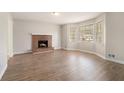 Bright living room featuring a brick fireplace, large windows, and stylish wood-look flooring at 1512 Daniel Ln, Lawrenceville, GA 30046