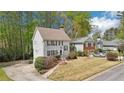 View of a two-story home with charming details, a well-kept lawn, and mature trees on a sunny day at 4783 Deer Chase, Powder Springs, GA 30127
