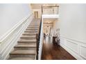 Grand foyer featuring a staircase with wrought iron railing, hardwood floors, and elegant wainscoting at 415 Damascus Ct, Fairburn, GA 30213