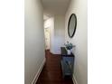 Hallway features wood floors, an oval mirror, and a blue accent table with plant at 61 N Auburn Landing Pl, Auburn, GA 30011
